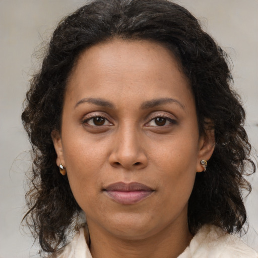 Joyful black adult female with medium  brown hair and brown eyes