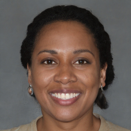 Joyful black adult female with short  black hair and brown eyes