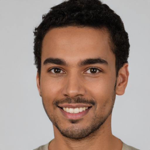 Joyful latino young-adult male with short  brown hair and brown eyes