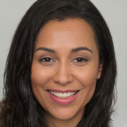 Joyful latino young-adult female with long  brown hair and brown eyes