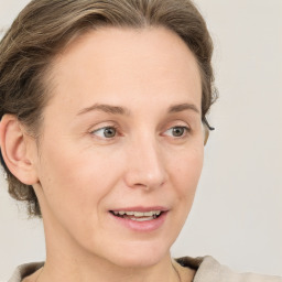 Joyful white adult female with medium  brown hair and grey eyes