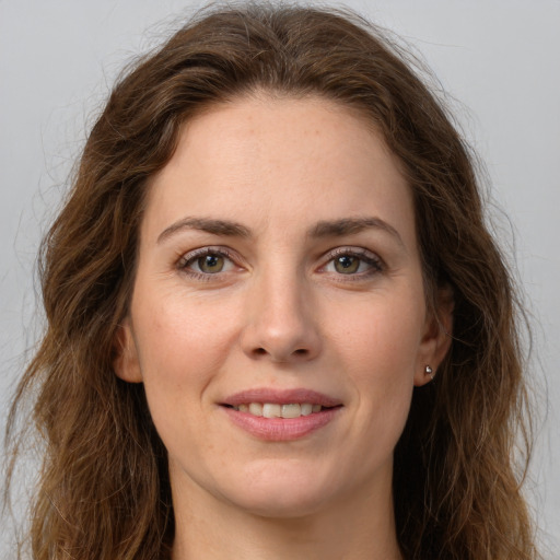 Joyful white young-adult female with long  brown hair and green eyes