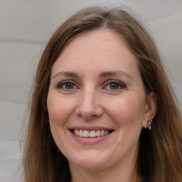 Joyful white adult female with long  brown hair and grey eyes