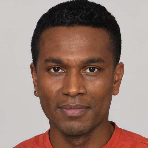 Joyful black young-adult male with short  black hair and brown eyes