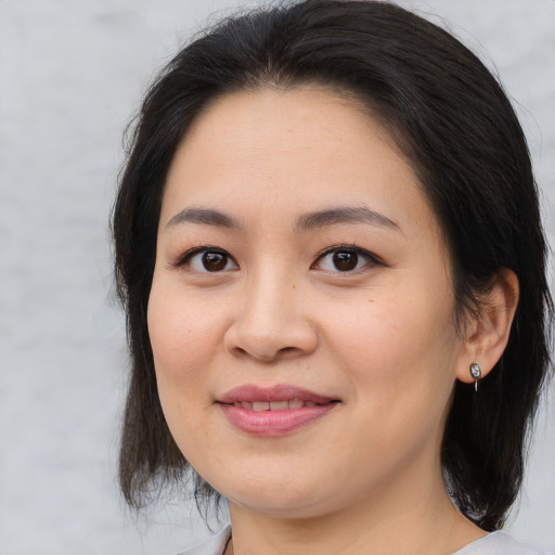 Joyful asian young-adult female with medium  brown hair and brown eyes