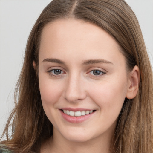 Joyful white young-adult female with long  brown hair and grey eyes