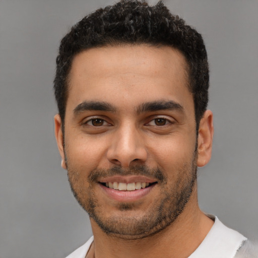 Joyful latino young-adult male with short  black hair and brown eyes