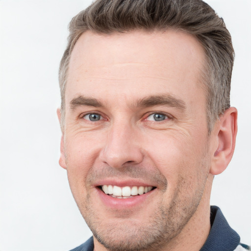 Joyful white adult male with short  brown hair and grey eyes