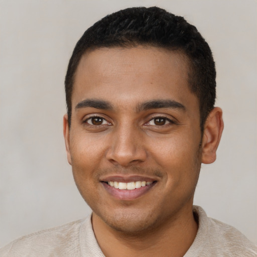 Joyful black young-adult male with short  brown hair and brown eyes