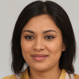 Joyful latino young-adult female with long  brown hair and brown eyes