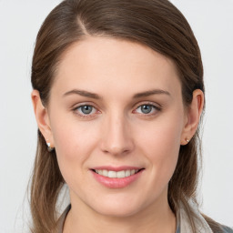 Joyful white young-adult female with long  brown hair and blue eyes