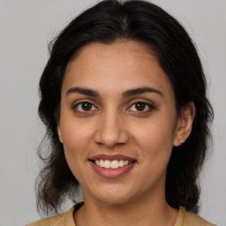 Joyful latino young-adult female with medium  brown hair and brown eyes