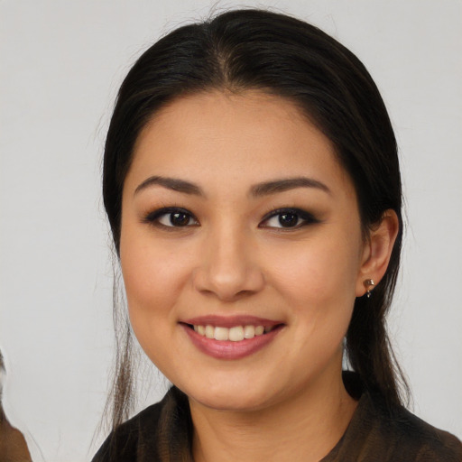 Joyful latino young-adult female with long  brown hair and brown eyes