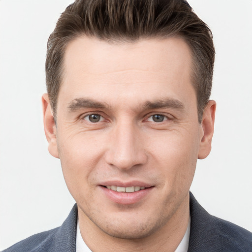 Joyful white young-adult male with short  brown hair and grey eyes