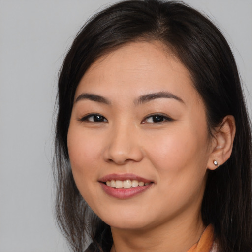 Joyful asian young-adult female with long  brown hair and brown eyes