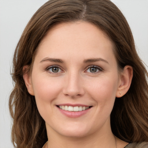 Joyful white young-adult female with long  brown hair and brown eyes