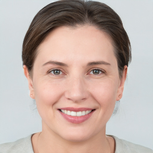 Joyful white young-adult female with medium  brown hair and grey eyes