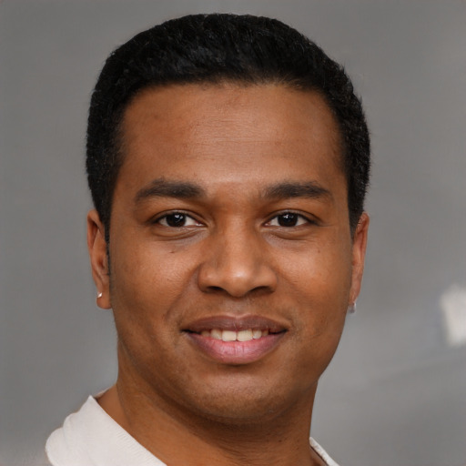 Joyful black young-adult male with short  brown hair and brown eyes