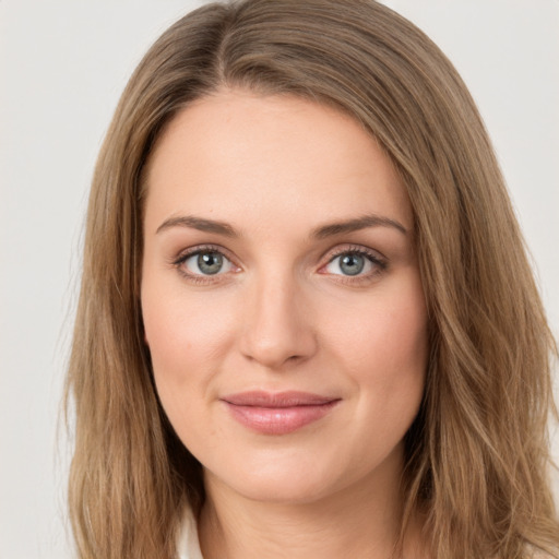 Joyful white young-adult female with long  brown hair and green eyes