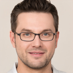 Joyful white young-adult male with short  brown hair and grey eyes