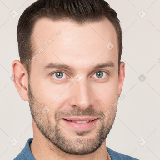 Joyful white young-adult male with short  brown hair and grey eyes