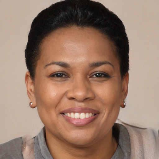 Joyful black adult female with short  brown hair and brown eyes