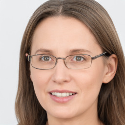 Joyful white adult female with long  brown hair and grey eyes