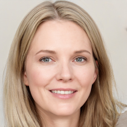 Joyful white adult female with long  brown hair and blue eyes