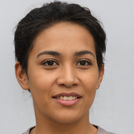 Joyful latino young-adult female with short  brown hair and brown eyes