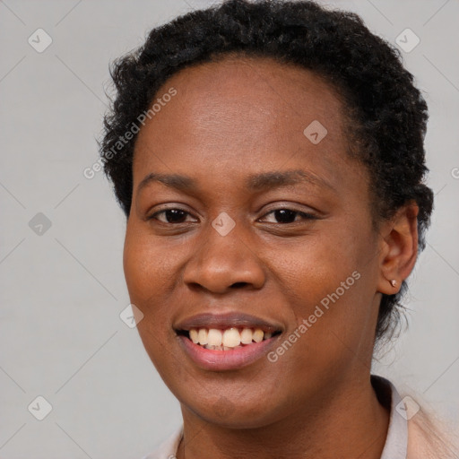 Joyful black young-adult female with short  brown hair and brown eyes