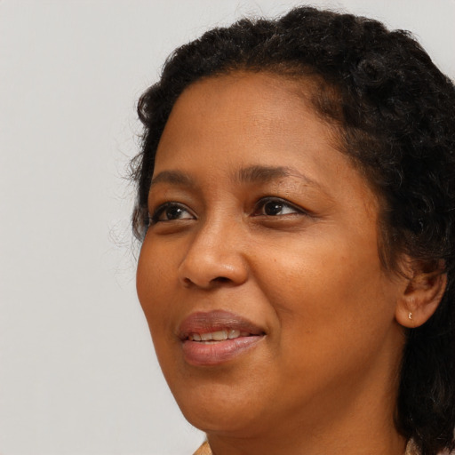 Joyful black young-adult female with long  brown hair and brown eyes