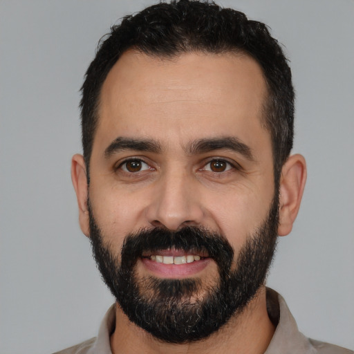 Joyful latino young-adult male with short  black hair and brown eyes