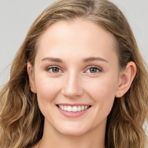 Joyful white young-adult female with long  brown hair and blue eyes