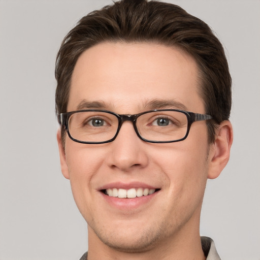 Joyful white young-adult male with short  brown hair and grey eyes