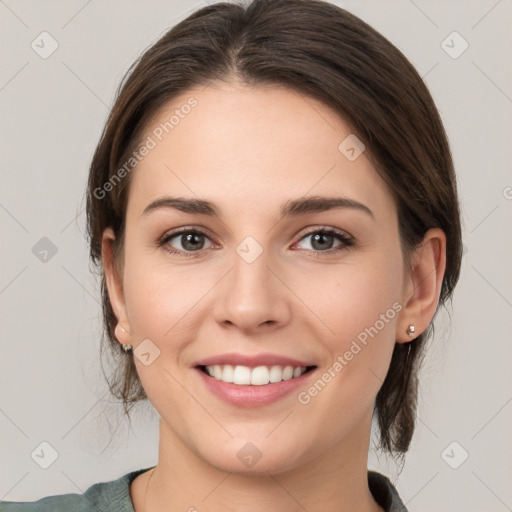 Joyful white young-adult female with medium  brown hair and grey eyes