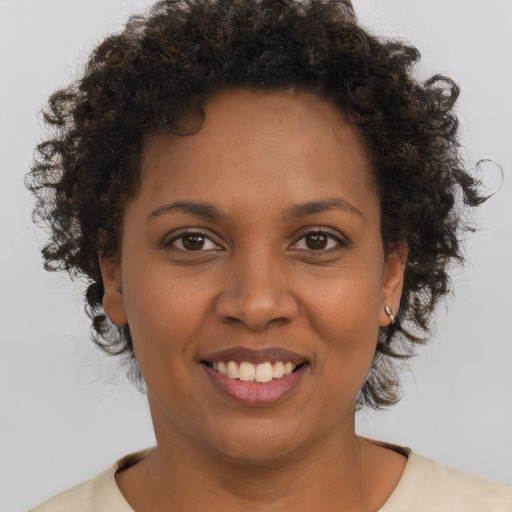 Joyful black young-adult female with short  brown hair and brown eyes