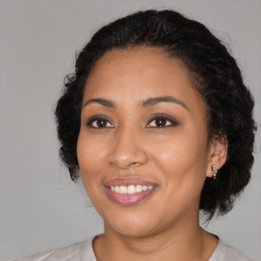 Joyful latino adult female with medium  black hair and brown eyes