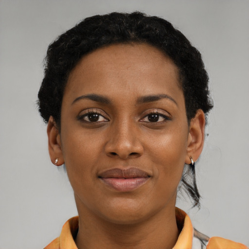Joyful black young-adult female with short  brown hair and brown eyes