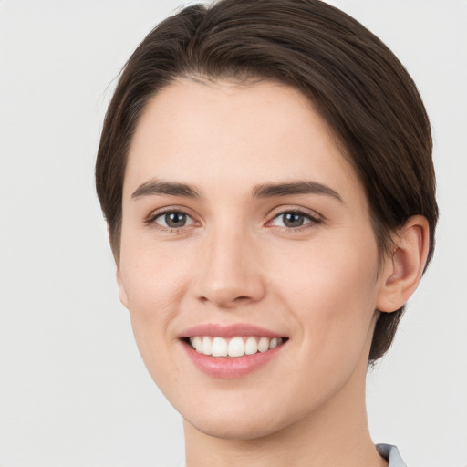 Joyful white young-adult female with short  brown hair and brown eyes