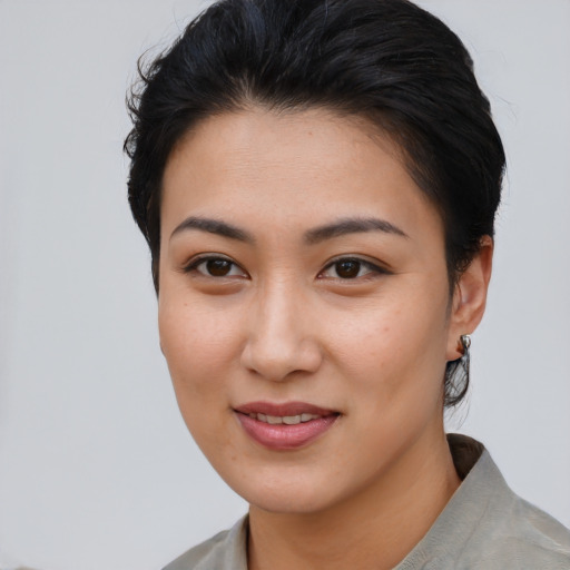 Joyful asian young-adult female with short  brown hair and brown eyes