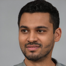 Joyful black young-adult male with short  black hair and brown eyes