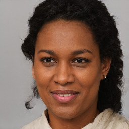 Joyful black adult female with medium  brown hair and brown eyes