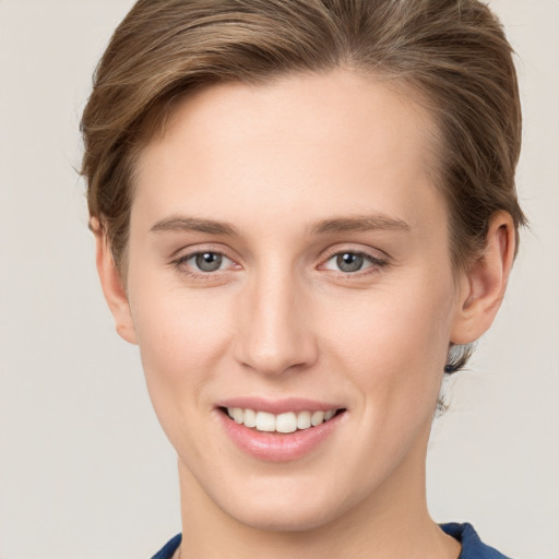 Joyful white young-adult female with short  brown hair and grey eyes