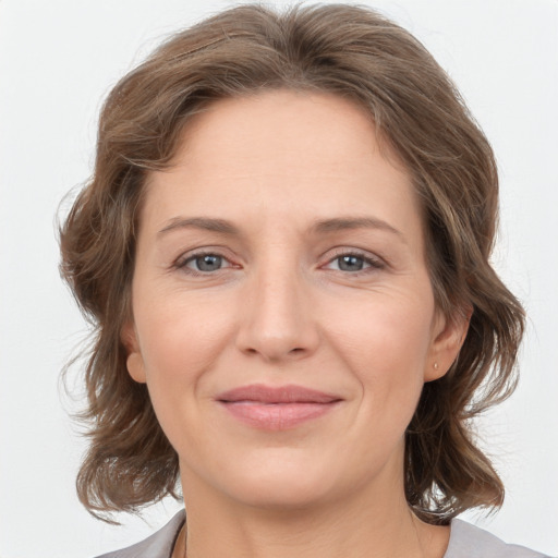 Joyful white young-adult female with medium  brown hair and grey eyes