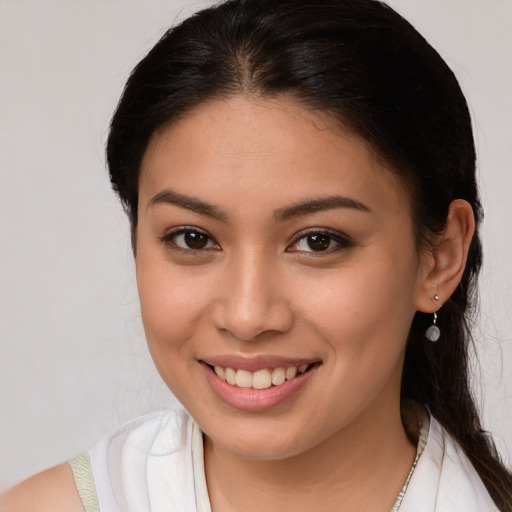 Joyful latino young-adult female with long  brown hair and brown eyes