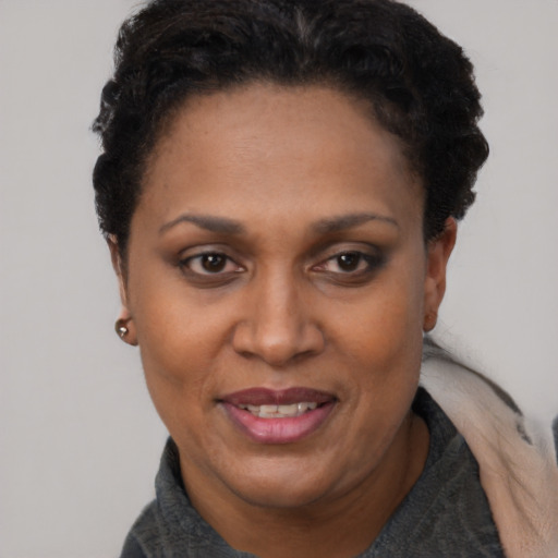 Joyful black adult female with short  black hair and brown eyes