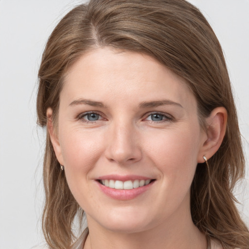 Joyful white young-adult female with long  brown hair and blue eyes