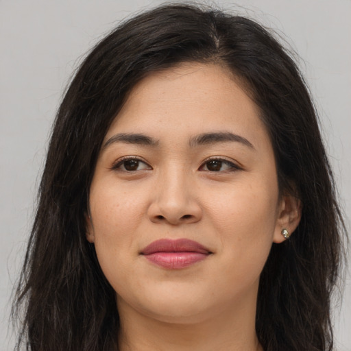 Joyful asian young-adult female with long  brown hair and brown eyes
