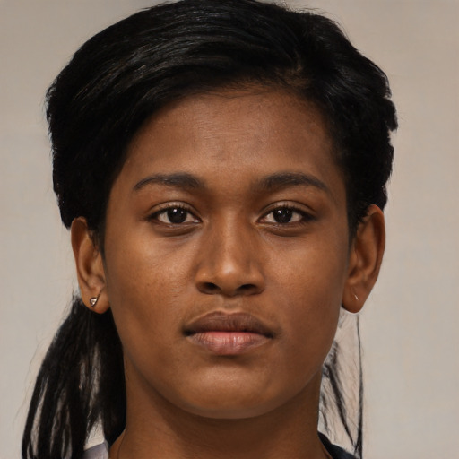 Joyful black young-adult female with long  brown hair and brown eyes