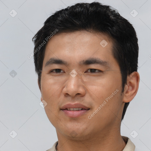 Joyful asian young-adult male with short  black hair and brown eyes